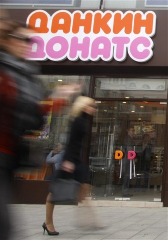 Pedestrians walk outside a new Dunkin' Donuts cafe on Wednesday in Moscow, Russia. 
